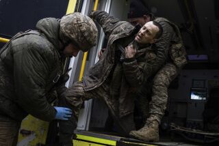 Médicos militares ucranianos ayudan a su camarada herido a salir de una ambulancia después de llegar del campo de batalla a un hospital de campaña cerca de Bájmut, Ucrania, el 26 de febrero de 2023. (AP Foto/Evgeniy Maloletka)