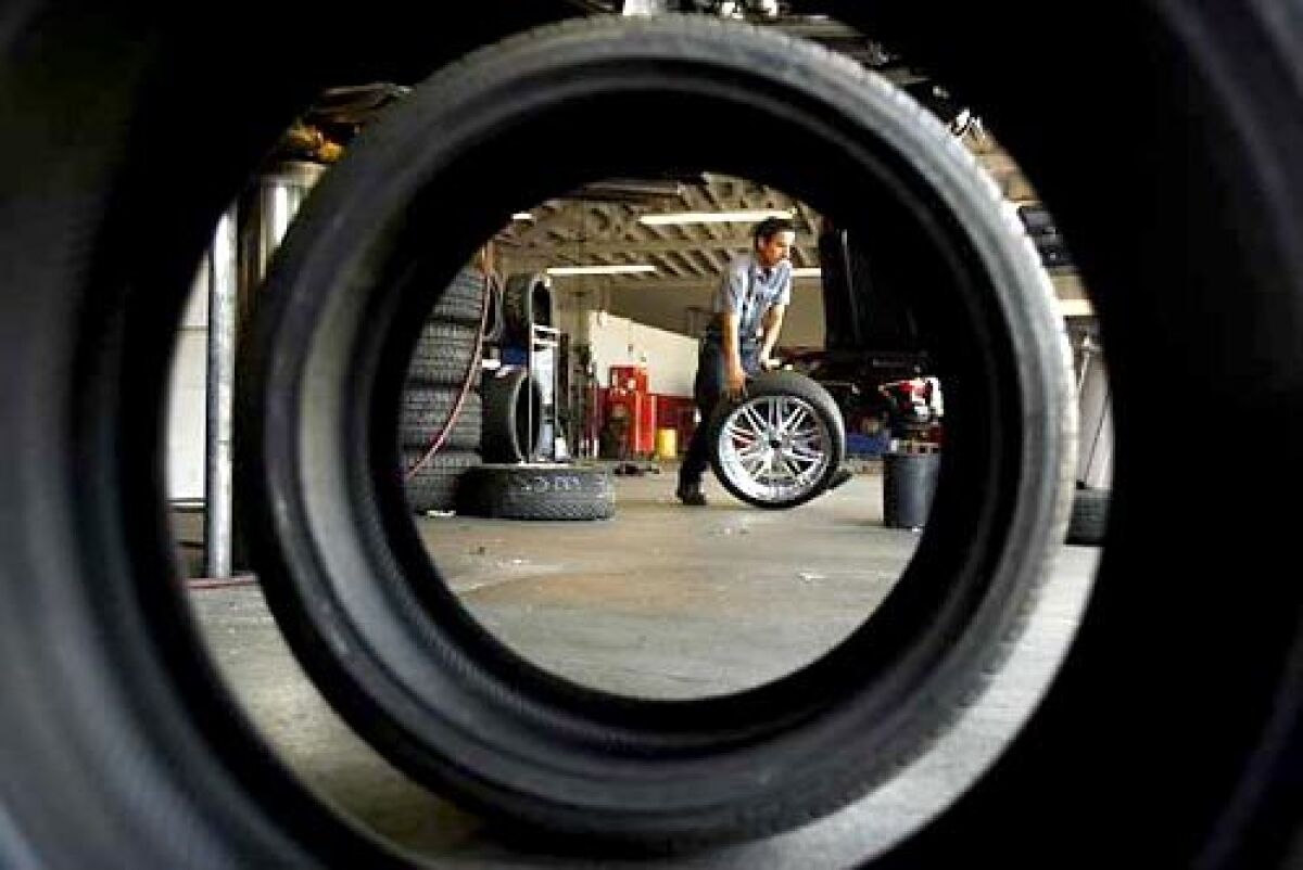 Jose Castillo, a technician at All Star Tire in Long Beach, prepares to balance a tire. Some customers are buying more fuel-efficient tires, but others choose style over efficiency.