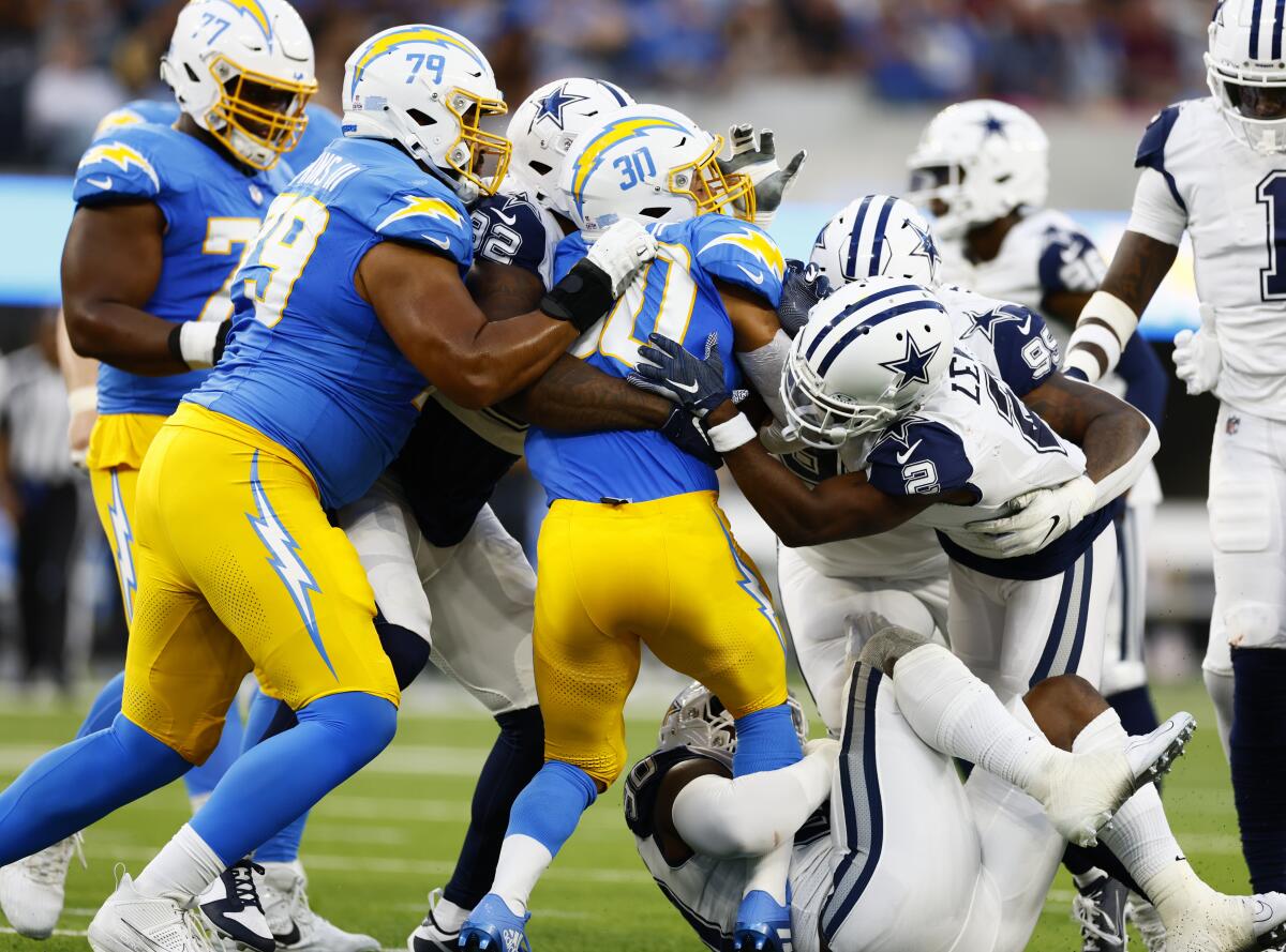 The Chargers' Austin Ekeler is stacked up at the line of scrimmage by the Dallas Cowboys.