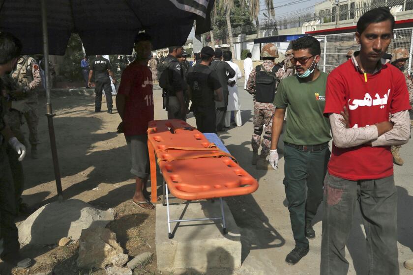 Volunteers wait outside the Chinese Consulate after an attack in Karachi, Pakistan, Friday, Nov. 23, 2018. Pakistani police say gunmen have stormed the Chinese Consulate in the country's southern port city of Karachi, triggering an intense shootout. (AP Photo/Shakil Adil)