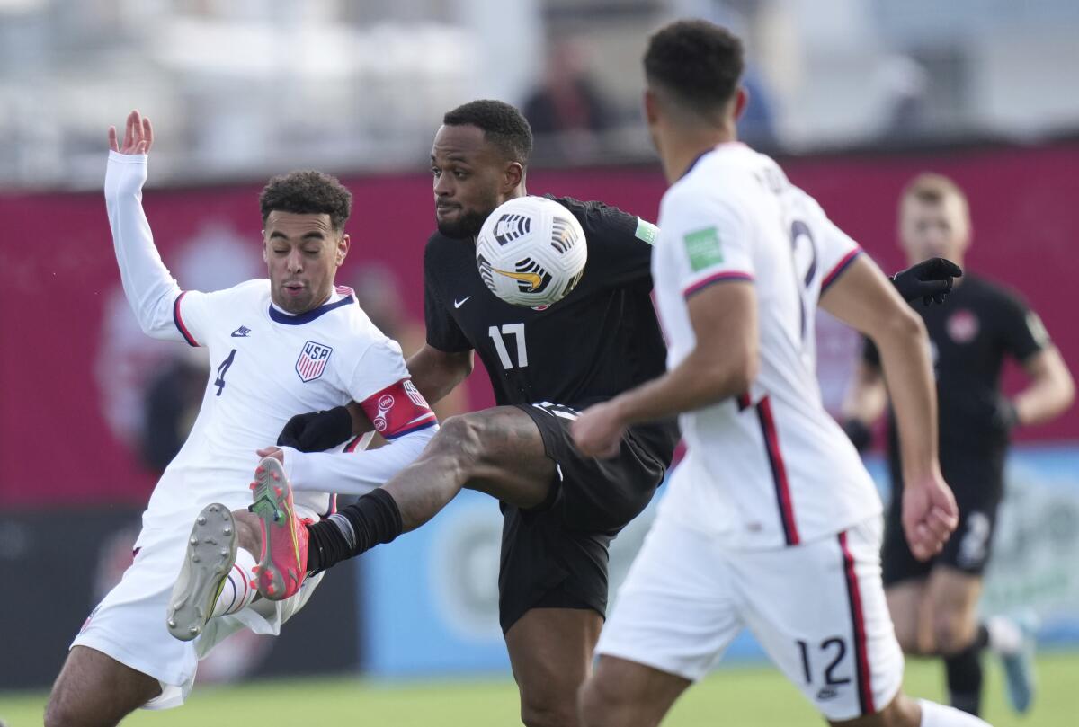 Canada's Cyle Larin (17) battles United States' Tyler Adams (4) for control of the ball during the first half.
