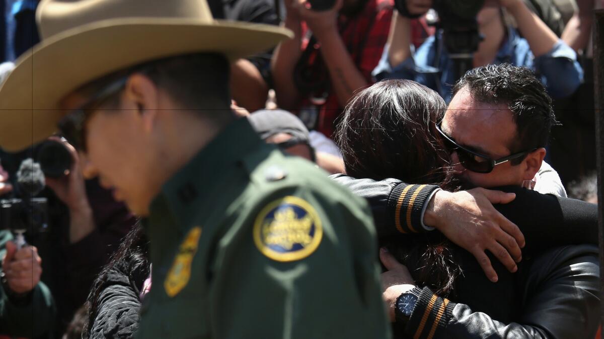 Under the supervision of the U.S. Border Patrol, families reunite at the fence separating San Diego and Tijuana in April.