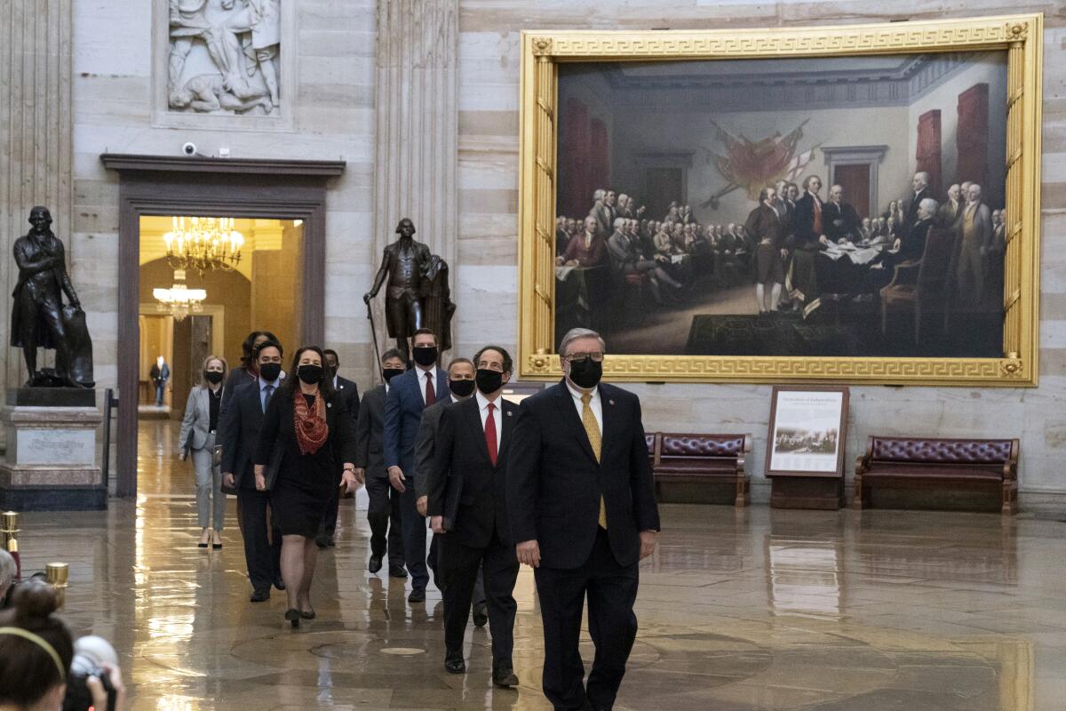 House impeachment managers walk through the Capitol Rotunda toward the Senate on Tuesday. 