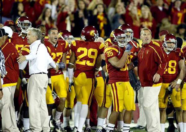 USC Coach Pete Carroll and an assistant try to keep the Trojans on their sideline after some words were exchanged with the Bruins and players spilled onto the field in the final minute of the game Saturday night.