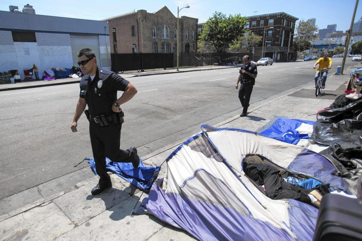 Los oficiales de policía de Los Ángeles patrullan la calle 6 en Skid Row.