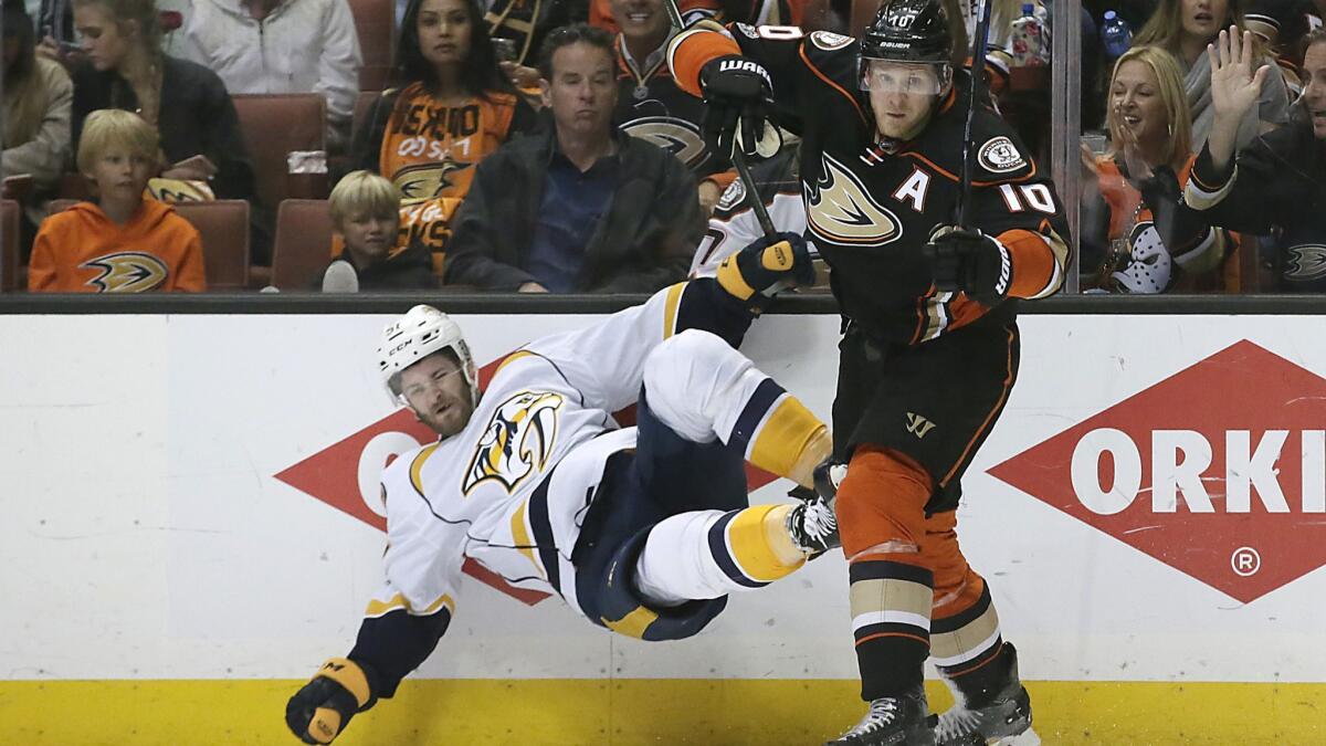 Ducks forward Corey Perry checks Predators forward Austin Watson to the ice during first period action in Game 2 of the NHL Western Conference finals at Honda Center.
