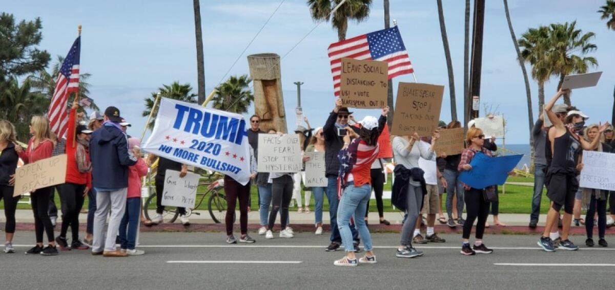 Roughly 200 protesters crowded a roadside in Encinitas on Sunday, April 19, 2020 to call for local officials to reopen beaches and trails.