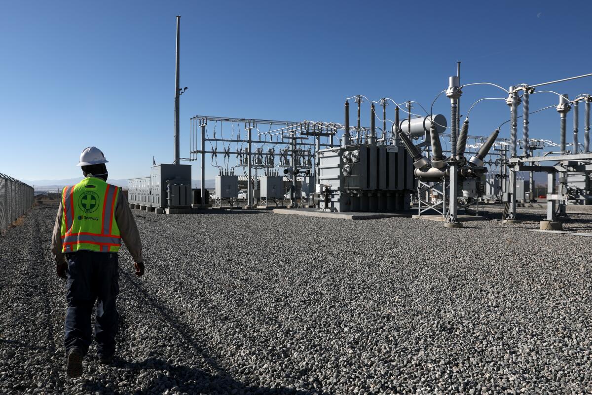 A person outdoors at an electric substation.