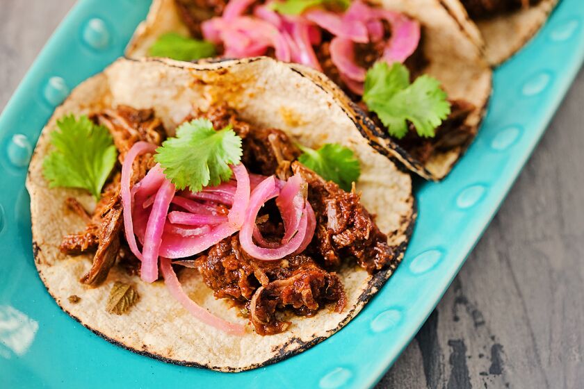 Adobo braised beef tacos with pickled red onions.