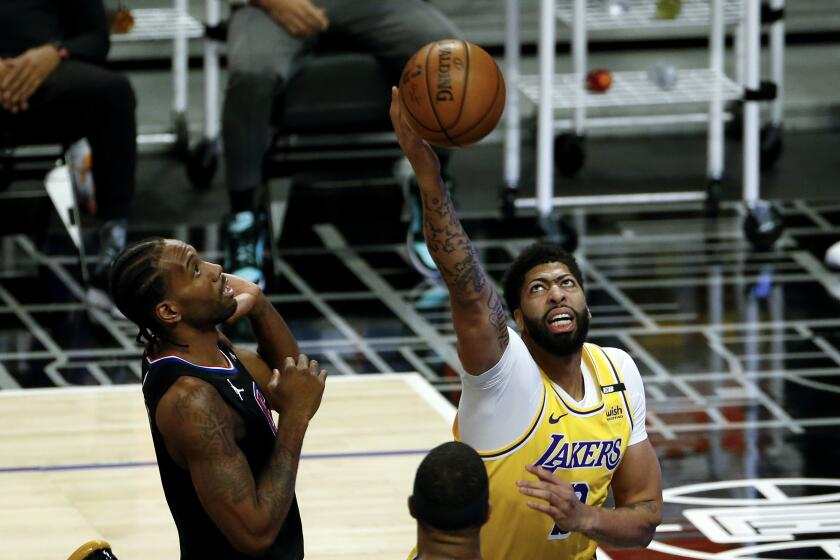 Los Angeles Lakers' Anthony Davis, right, goes up to basket next to Los Angeles Clippers' Kawhi Leonard, left, during the first half of an NBA basketball game, Thursday, May 6, 2021, in Los Angeles. (AP Photo/Ringo H.W. Chiu)