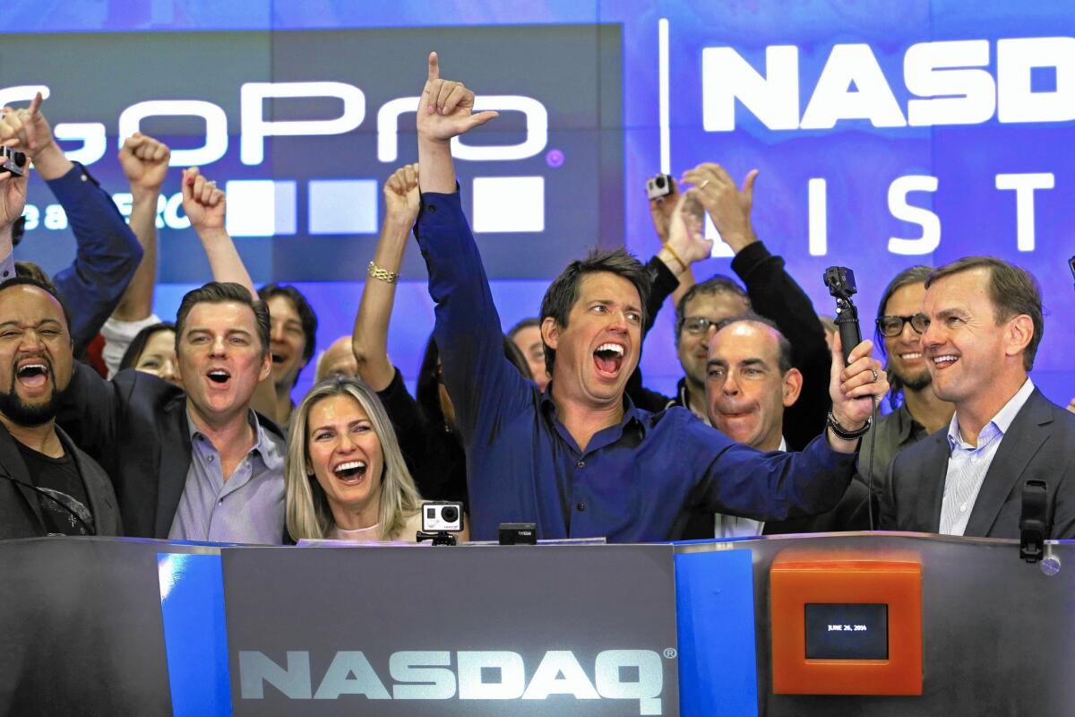 The stock market slide could lead to fewer initial public offerings by tech start-ups. Above, GoPro CEO Nick Woodman, center, celebrates his company’s IPO in June 2014. The firm is growing fast on the backs of U.S. consumers — where demand remains strong.