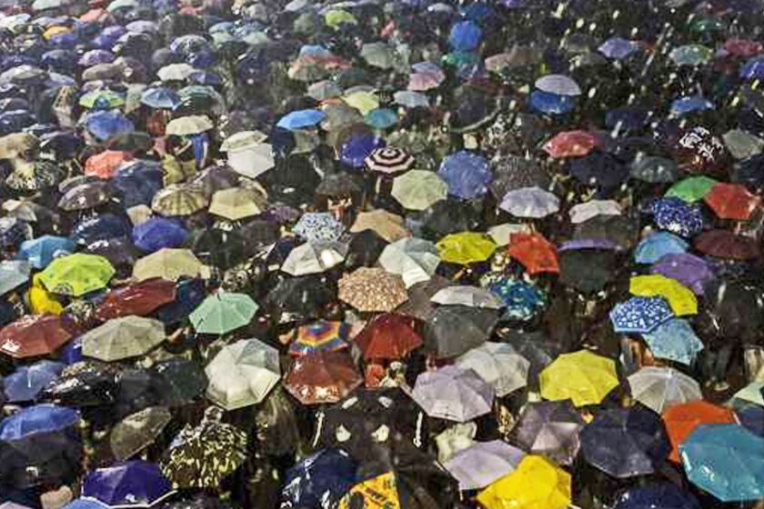 Pro-democracy protestors use umbrellas to shield themselves from heavy rain in Hong Kong on Sept. 30.
