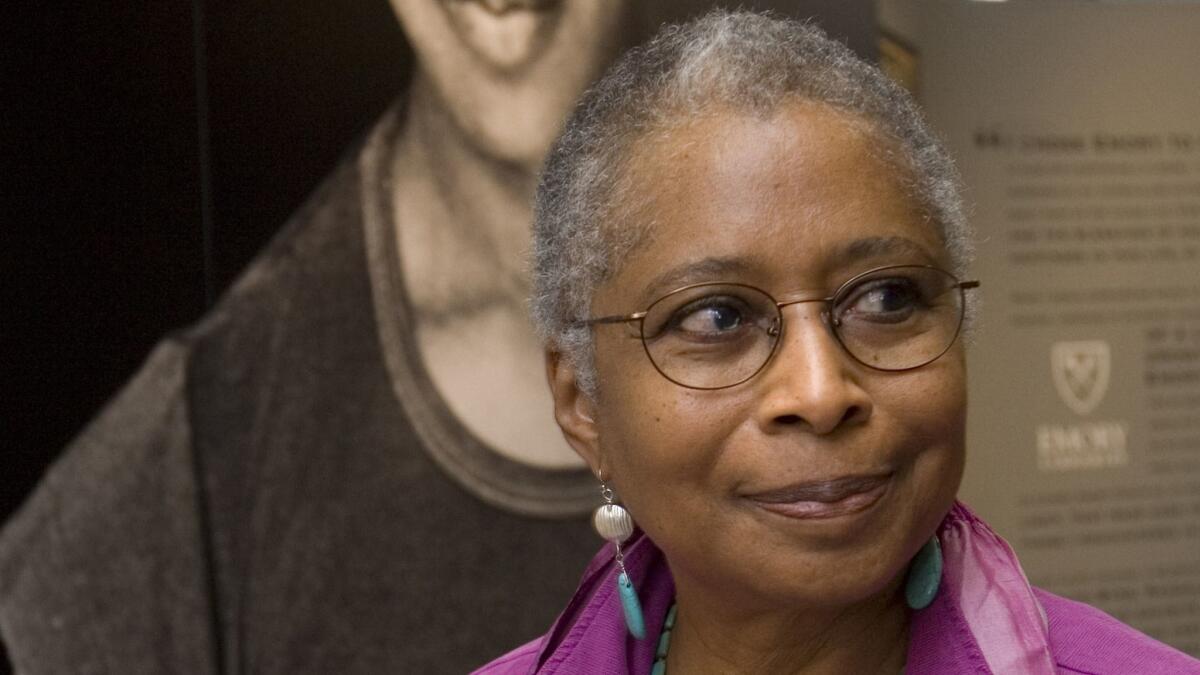 In this April 23, 2009 file photo, Alice Walker stands in front of a picture of herself from 1974 as she tours her archives at Emory University, in Atlanta.