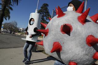 San Juan Capistrano, CA, Friday, February 25, 2022 - At least once a week, Socorro Juarez dresses up as a vaccine syringe and dances around trying to convince fellow Latinos to get vaccinated and boosted. Rosa Cardona, right, dressed as the Corona virus, joins her on Camino Capistrano. (Robert Gauthier/Los Angeles Times)