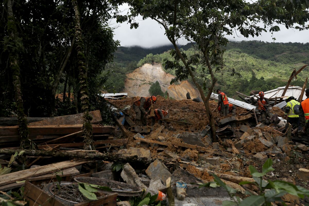 Rescue teams search for survivors after a rain-fueled landslide in the village of Queja, Guatemala, on Saturday.