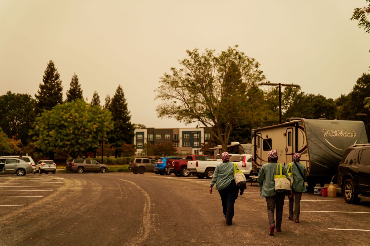 Nurses Jenn Ellis, Blanca Ramirez, and  Bindhi Millar walk the parking lot of the Vacaville Community Center