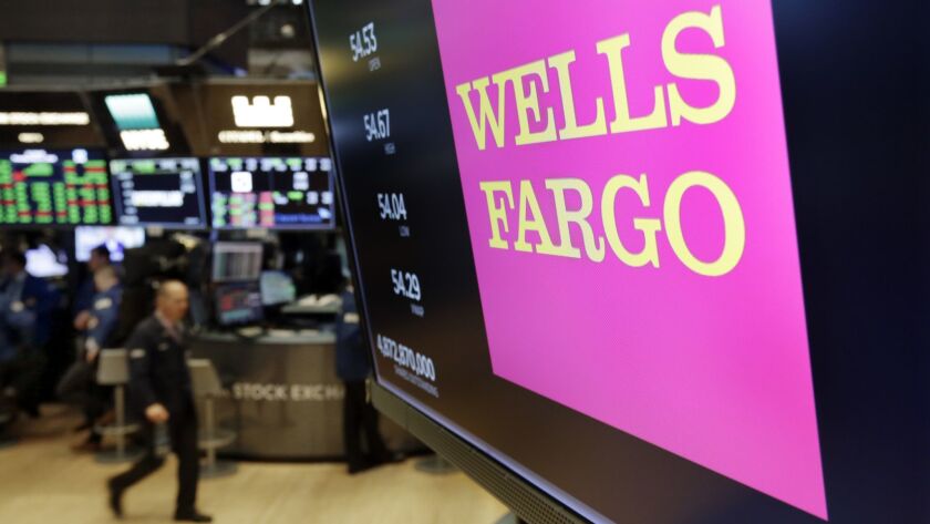 The Wells Fargo logo above a trading post on the floor of the New York Stock Exchange. Regulators say brokers with Wells Fargo Advisors encouraged retail customers to sell market-linked investments meant to be held to maturity so they could replace them with new products.