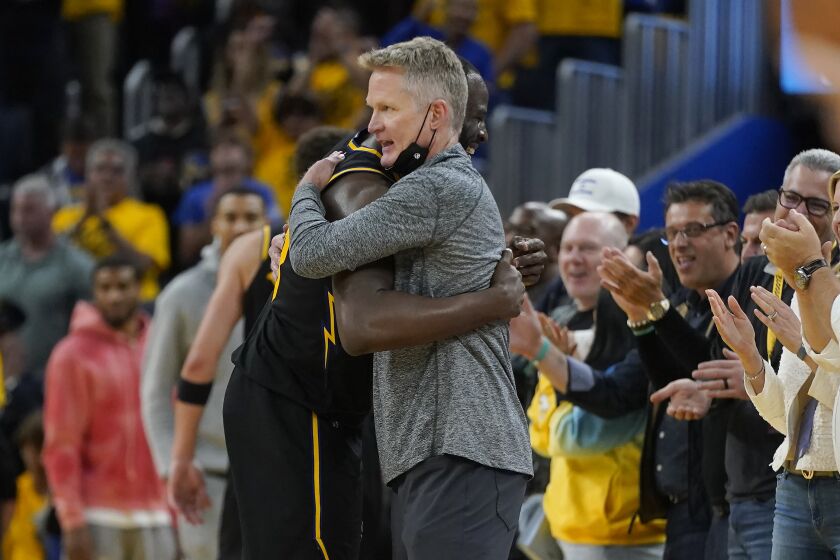 Golden State Warriors head coach Steve Kerr, center right, hugs Draymond Green during the second half of Game 5 of the NBA basketball playoffs Western Conference finals against the Dallas Mavericks in San Francisco, Thursday, May 26, 2022. (AP Photo/Jeff Chiu)