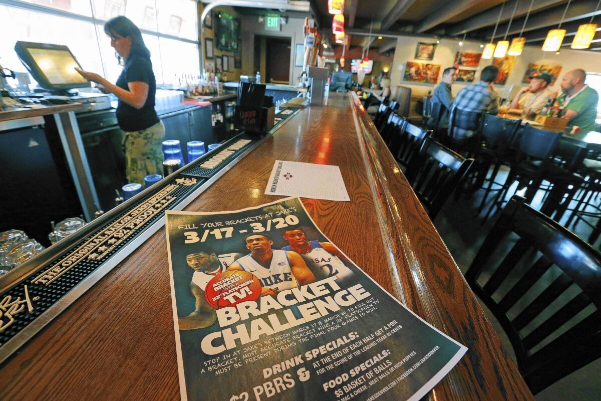 A poster advertises the "Bracket Challenge," whereby patrons can complete an NCAA basketball tournament bracket at Jake's sports bar in Denver.