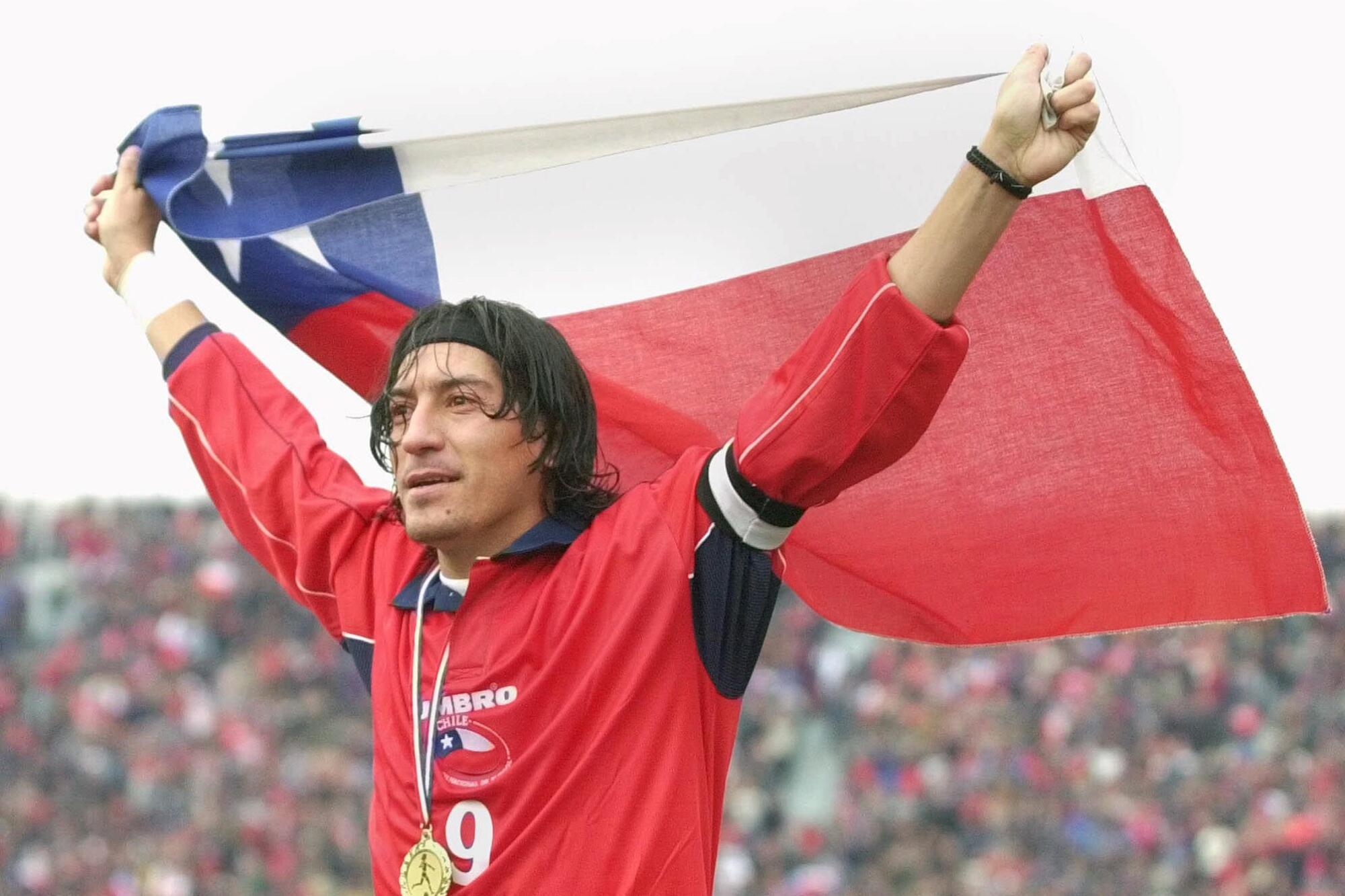 Chilean star soccer player Ivan Zamorano holds a Chilean flag after defeating France's national soccer team 2-1 in Santiago