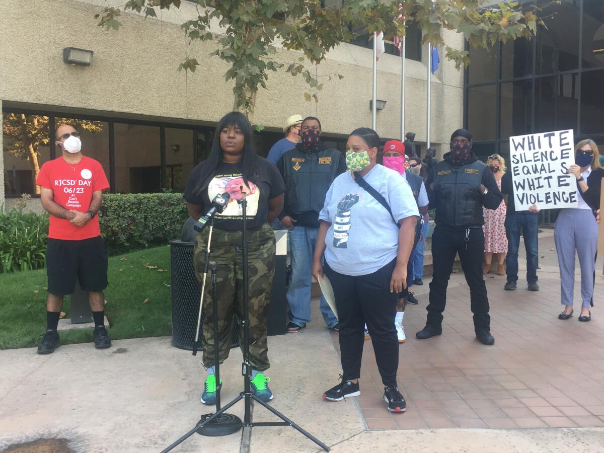 Shynita Phillips Abu, alongside activists and community members, speaks at a news conference.