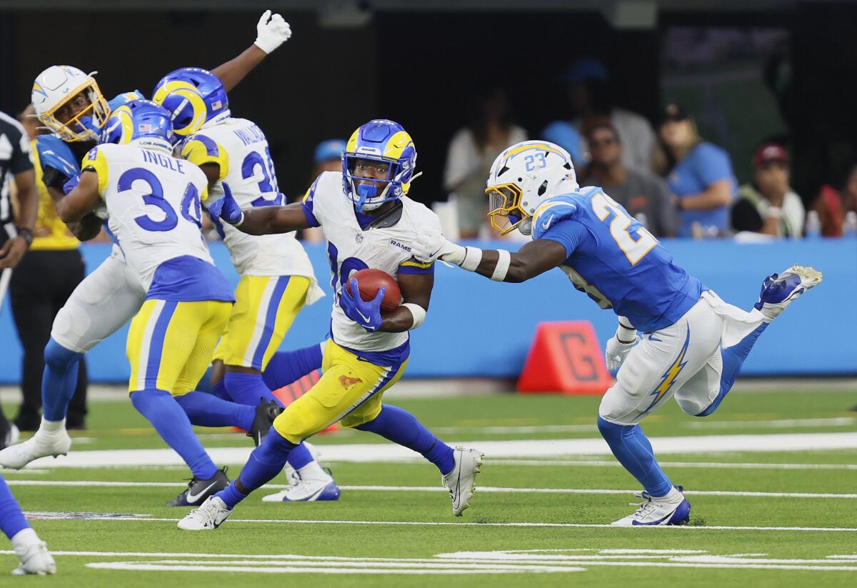 Rams receiver Xavier Smith runs with the football past Chargers cornerback Matt Hankins during their preseason game.