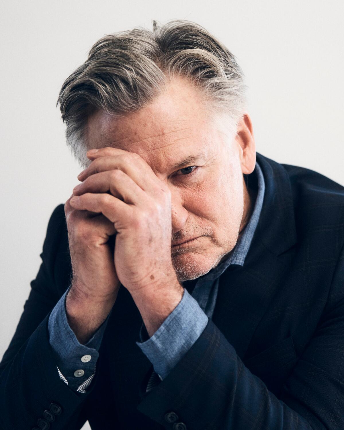 Bill Pullman rests his face on his hands for a portrait