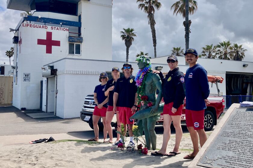 Ocean Beach lifeguards stand with OB's lifeguard statue on May 5 this year.