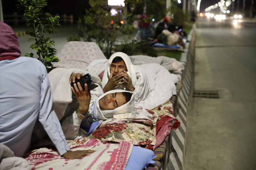 People sleep outside on a street in Katmandu, Nepal, following a massive earthquake on April 25.