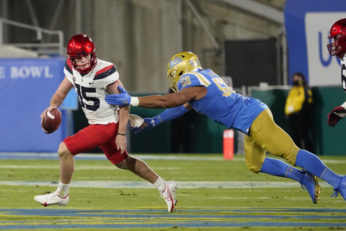 Arizona quarterback Will Plummer, left, is chased by UCLA defensive lineman Datona Jackson on Nov. 28, 2020.