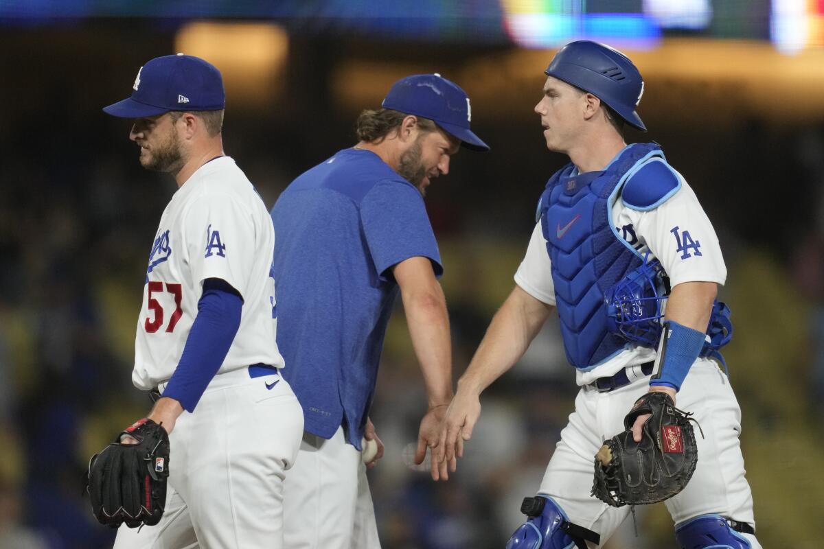 Dodgers pitcher Clayton Kershaw celebrates a win with reliever Ryan Brasier and catcher Will Smith.