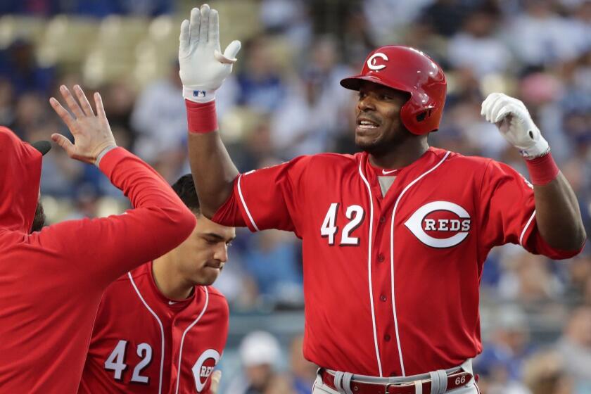 LOS ANGELES, CA - APRIL 15, 2019: Cincinnati Reds Yasiel Puig gets high-fives at the dugout after hitting a 2-run homer off Dodgers Clayton Kershaw in first inning at Dodger Stadium on April 15, 2019 in Los Angeles, California.(Gina Ferazzi/Los AngelesTimes)