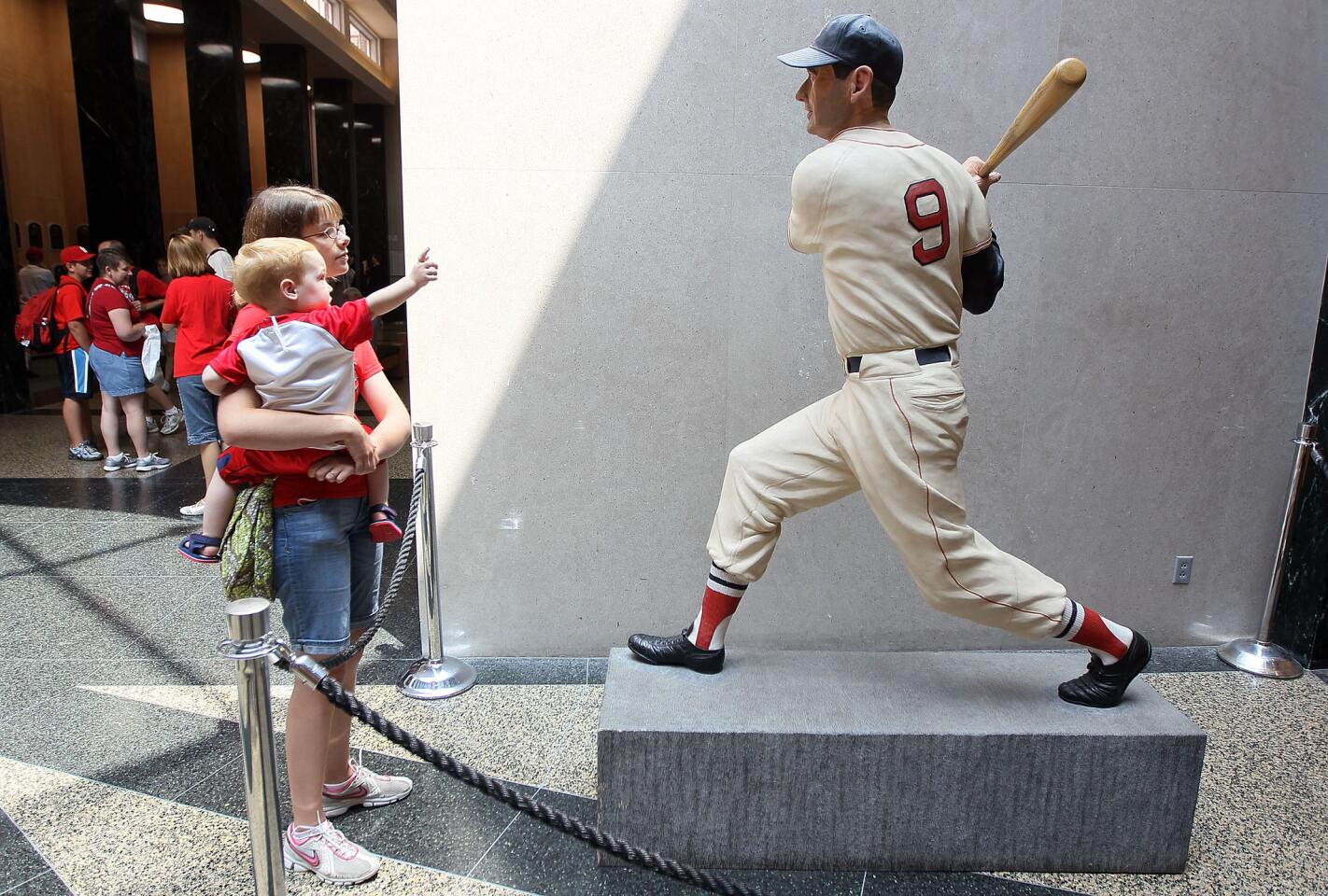 Visitors view a statue of Ted Williams at the baseball Hall of Fame.