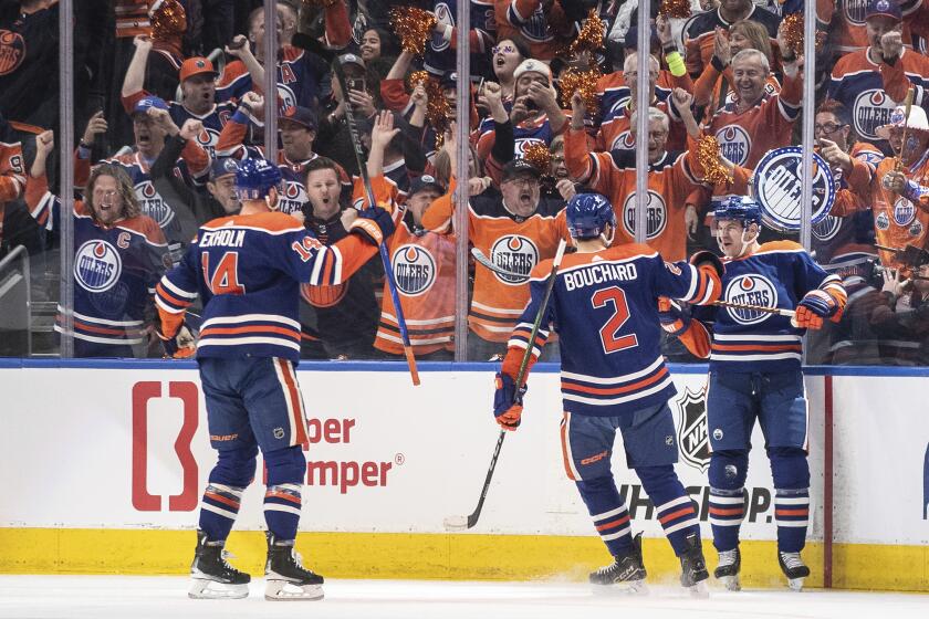 Edmonton Oilers' Mattias Ekholm (14), Evan Bouchard (2) and Zach Hyman (18) celebrate after a goal against the Los Angeles Kings during the first period of Game 1 in first-round NHL Stanley Cup playoff hockey action in Edmonton, Alberta, Monday, April 22, 2024. (Jason Franson/The Canadian Press via AP)
