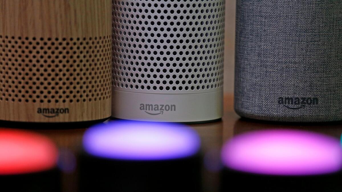 Amazon Echo and Echo Plus devices sit near illuminated Echo Button devices.