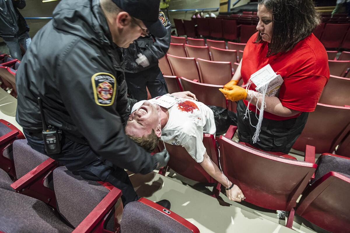 In a training drill at a Kentucky school, local emergency responders practice treating a student covered with fake blood for a gunshot to the chest.