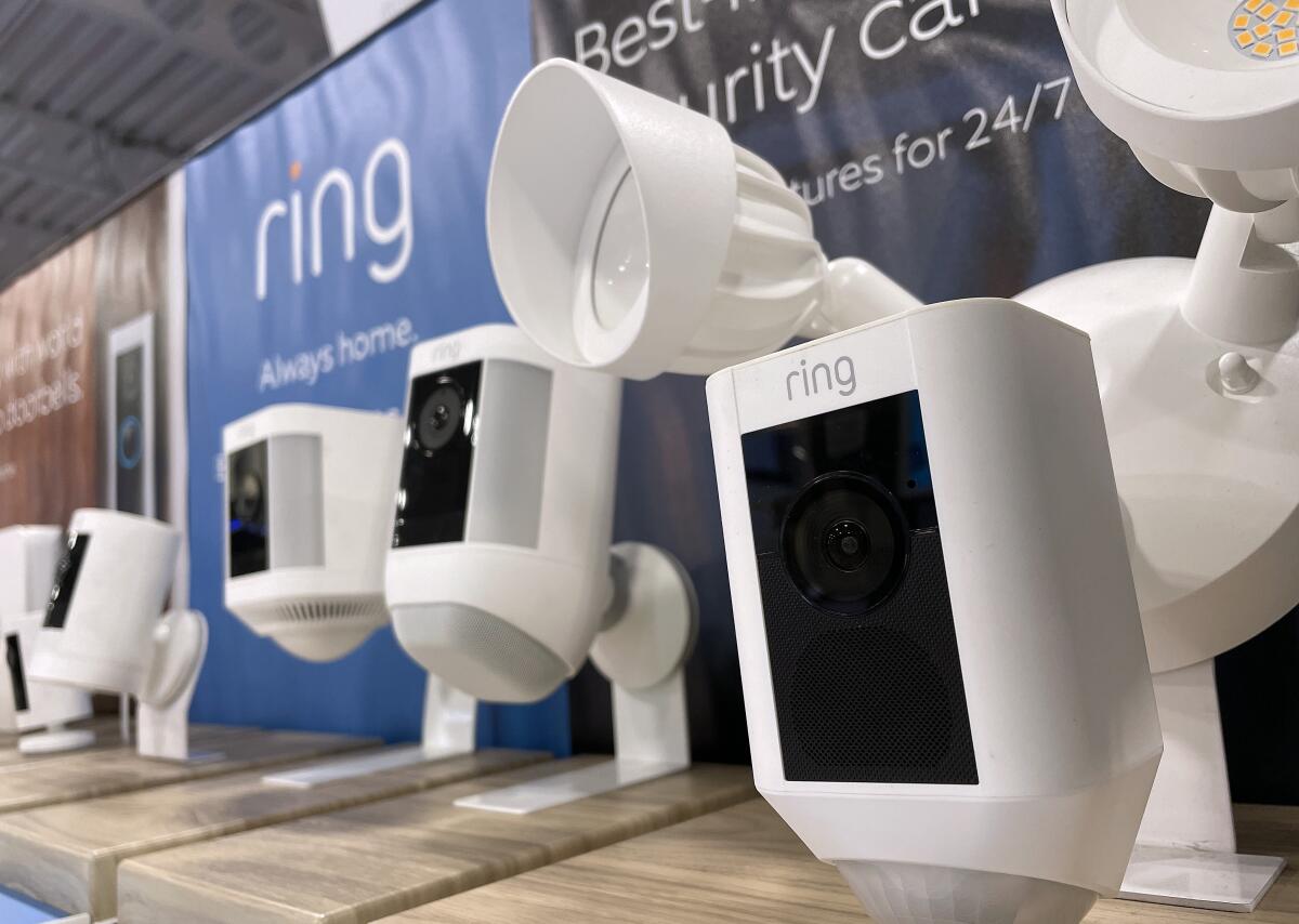 Ring security cameras are displayed on a shelf at a store.