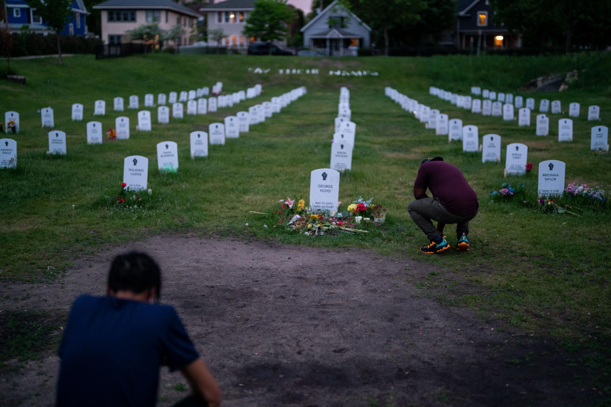 People visit and pay their respects at the Say Their Names Cemetery near the George Floyd Memorial Square on Monday.