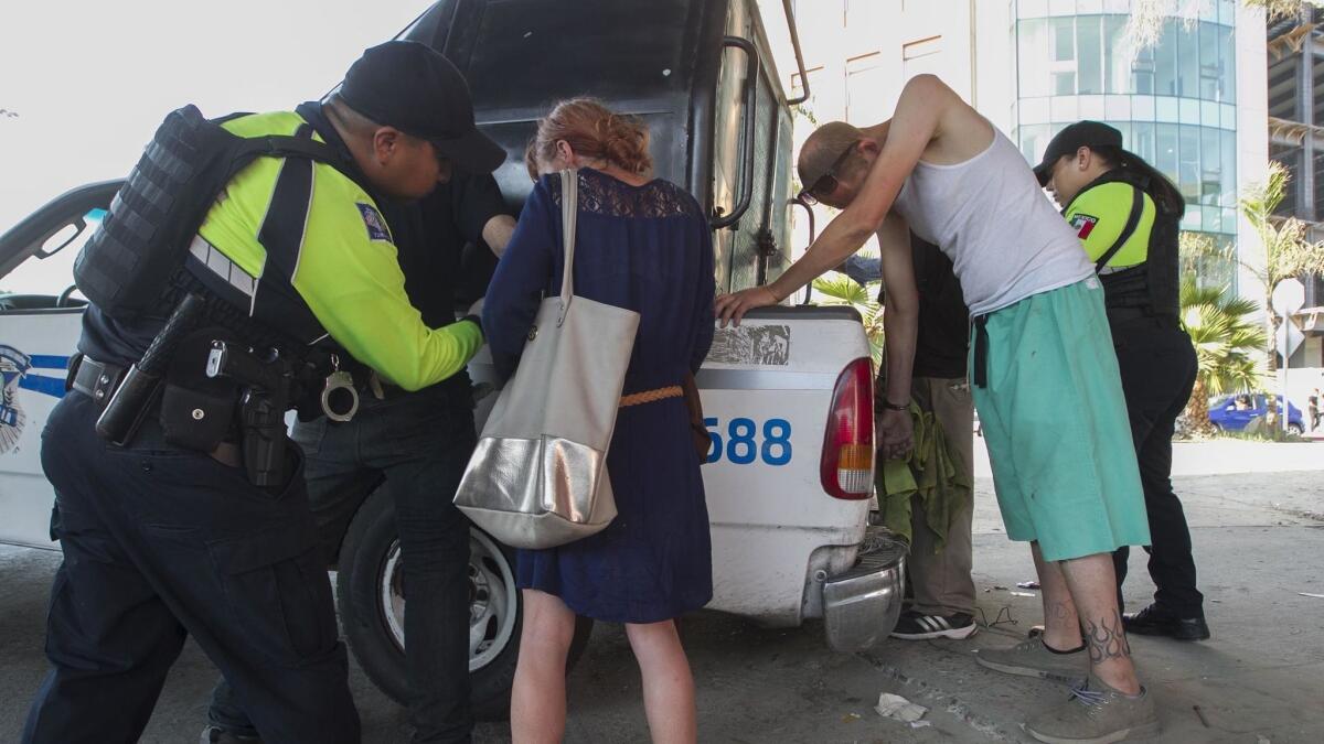 Officers assigned to the tourist section of the Tijuana Police Department process people rounded up at the port of entry who were allegedly engaging in illegal activities in the long line of cars waiting to go in to the US.