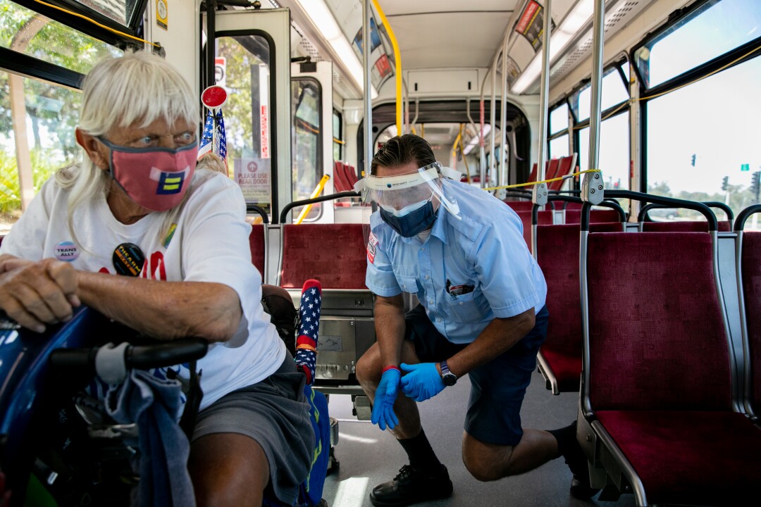 Christopher Castor, 56, helps a passenger in a wheelchair get secured into the number 7 bus.