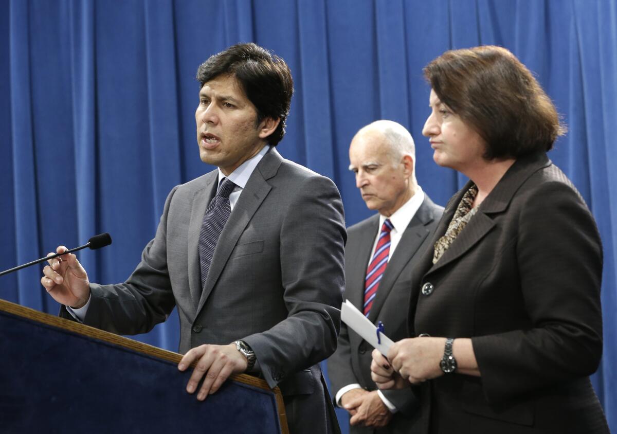 California state Senate President Pro Tem Kevin de León, left, accompanied by California Gov. Jerry Brown and Assembly Speaker Toni Atkins, announces he is scaling back a proposal to address climate change during a news conference on Wednesday in Sacramento.