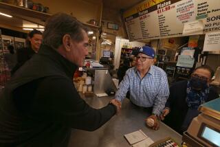 Los Angeles, CA - Dodgers legend Steve Garvey gives a signed baseball to Ruben Ramirez Sr. and his wife Alicia during a visit to Ruben's Bakery and Mexican Food Store in Compton on Thursday afternoon, Jan. 11, 2024. Garvey is campaigning to represent California in the United States Senate, an office that formerly was held by the late Sen. Dianne Feinstein. (photographer} / Los Angeles Times)