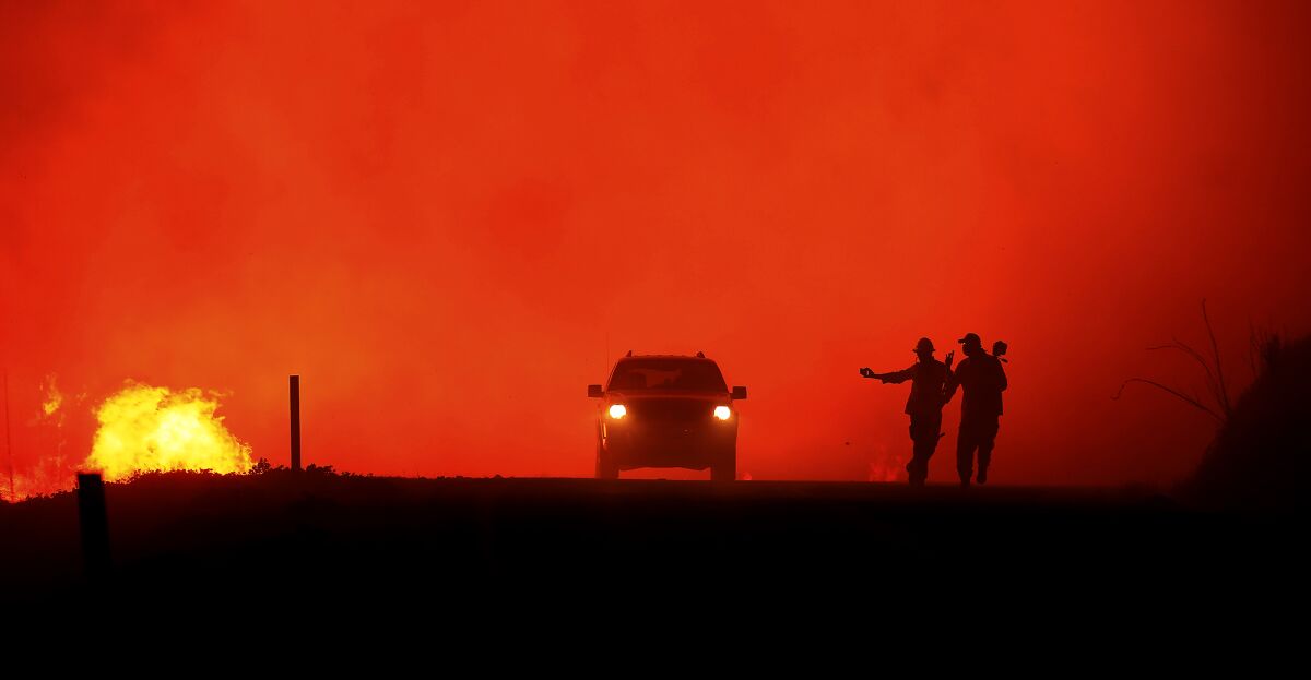 Photographers run as the Kincade fire approaches Geysers Road in Sonoma County