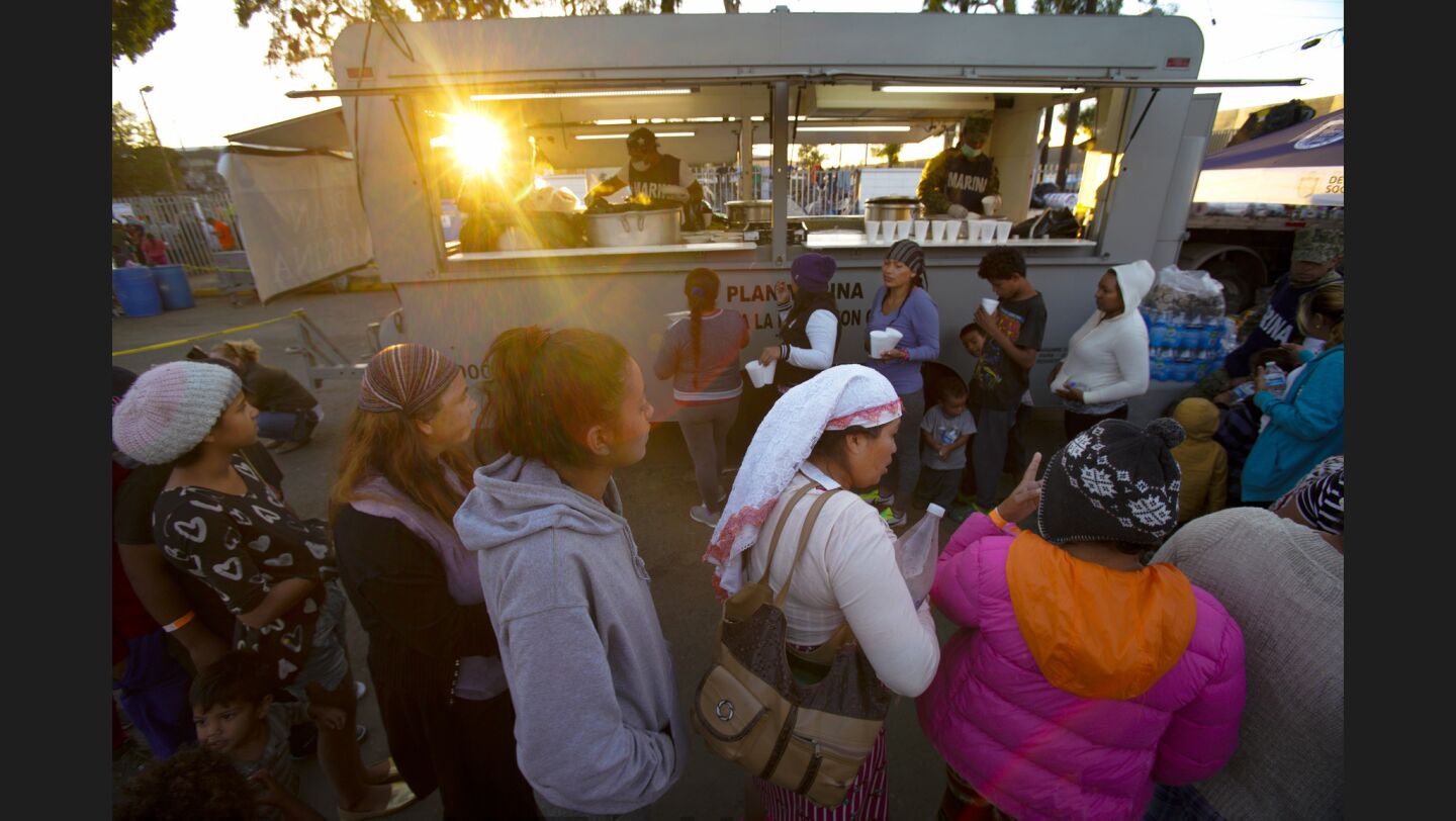 Women wait in line outside the Benito Juarez Sports Complex in Tijuana for dinner.