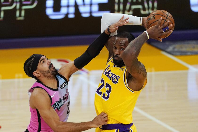Los Angeles Lakers forward LeBron James, right, tries to pass as Miami Heat guard Gabe Vincent defends during the first half of an NBA basketball game Saturday, Feb. 20, 2021, in Los Angeles. (AP Photo/Mark J. Terrill)