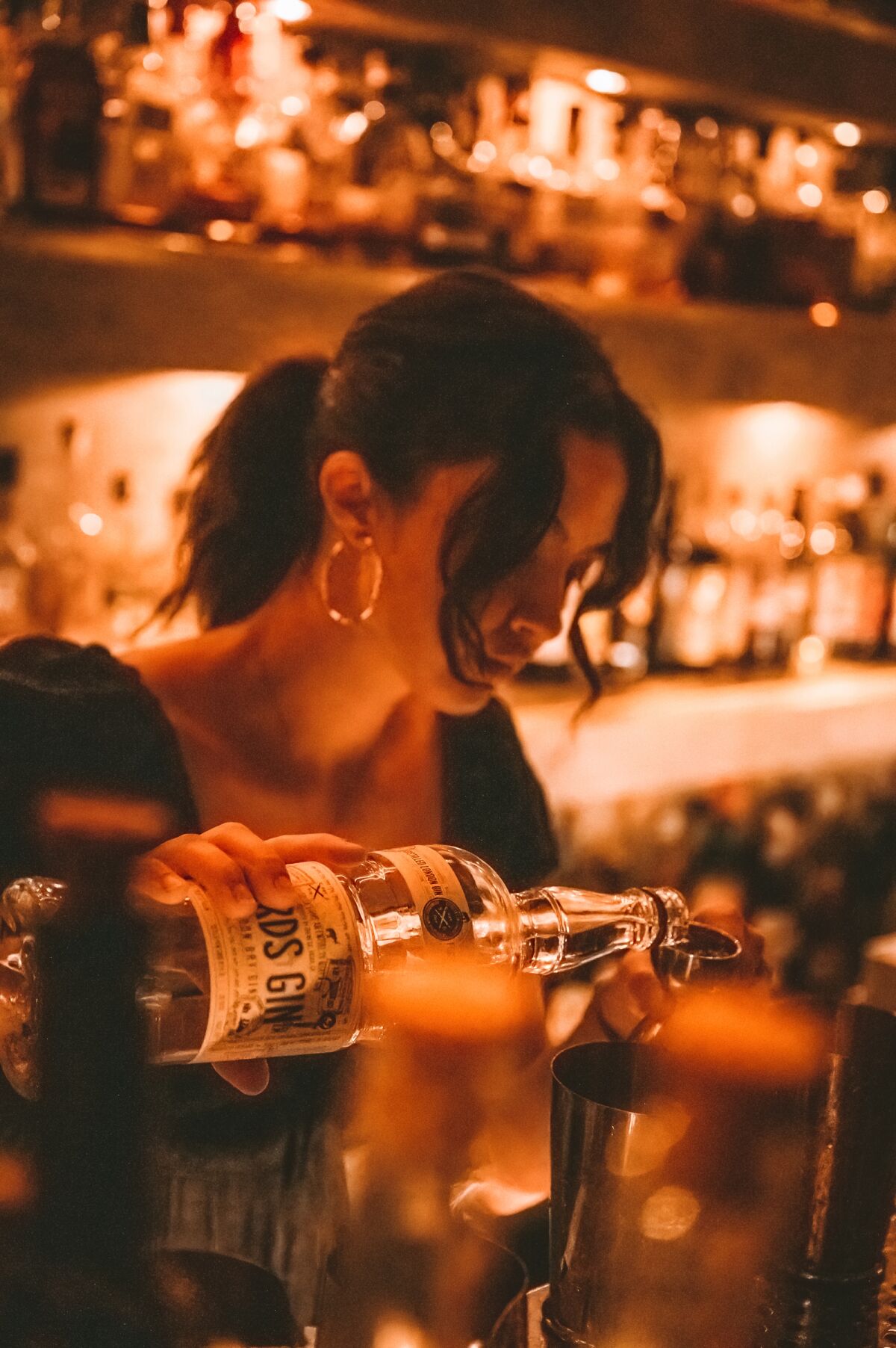A bartender mixes a cocktail at newly renovated Noble Experiment speakeasy in East Village San Diego.