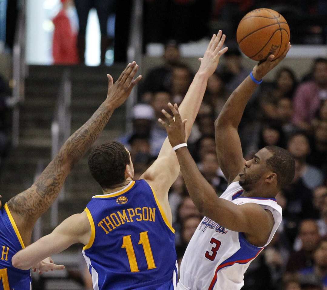 Clippers point guard Chris Paul, who finished with 28 points and 13 assists, lofts a floater over Warriors guard Klay Thompson in the second half Saturday afternoon at Staples Center.