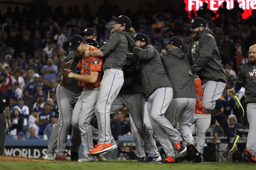 The Astros swarm pitcher Charlie Morton after he held the Dodgers to one run over the last four innings to preserve the win.
