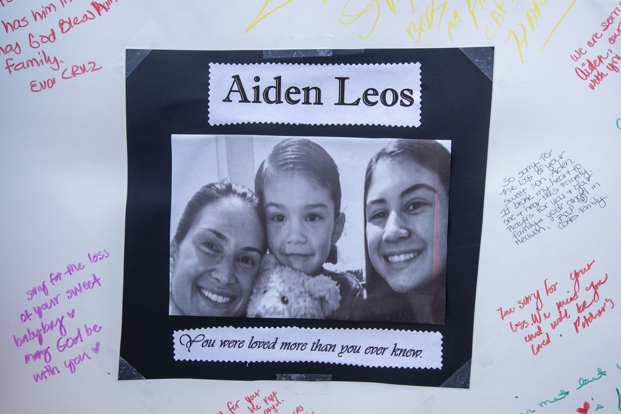 A poster with Aiden Leos' image hangs at a memorial for the 6-year-old on a 55 Freeway overpass in Orange.