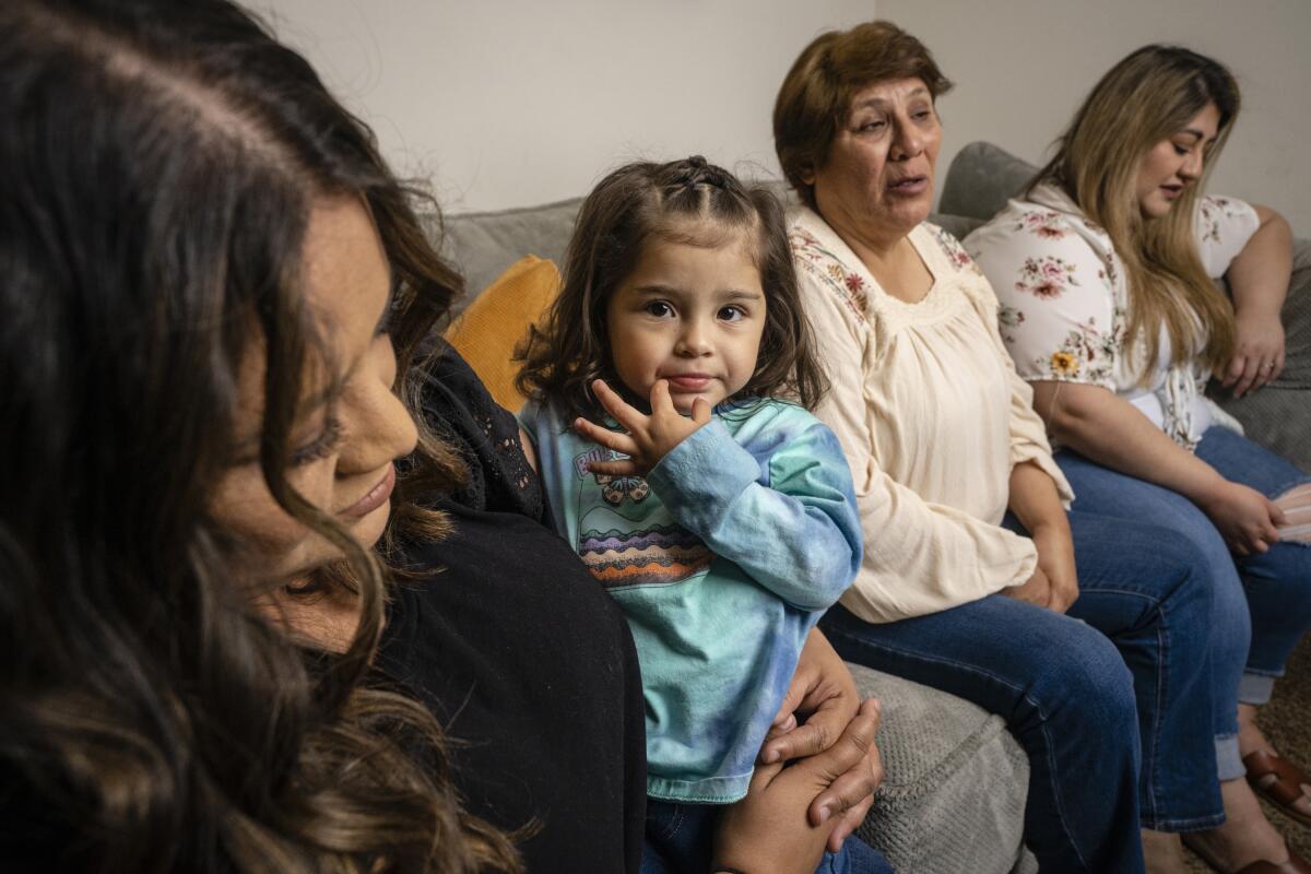 Family members sit on a couch